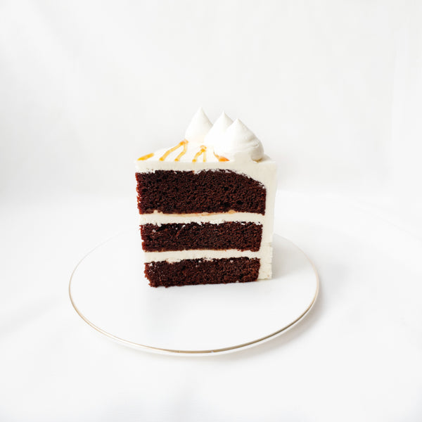 Slice of Chocolate earl grey cake drizzled with salted caramel and layered with silky vanilla buttercream
